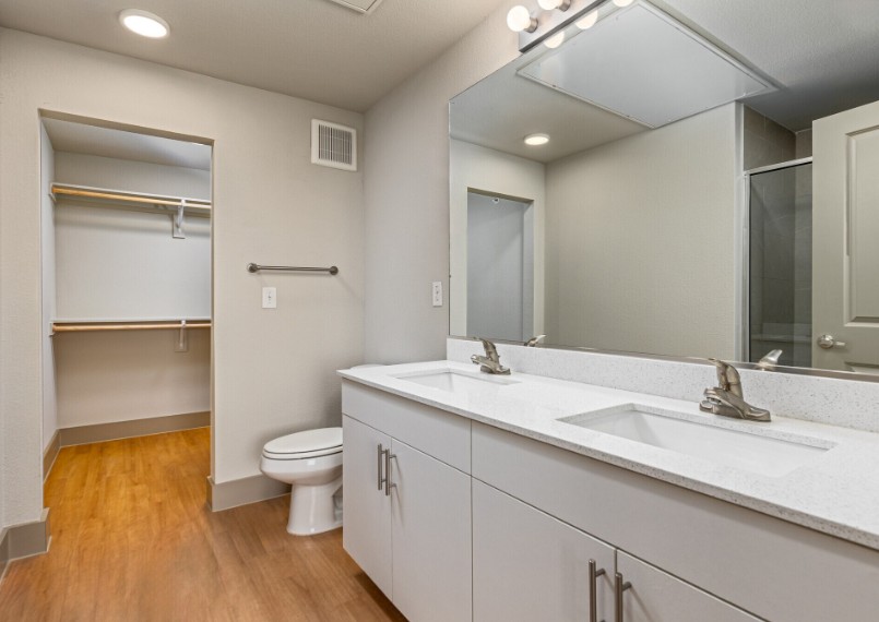A white bathroom with a toilet, sink, and mirror.